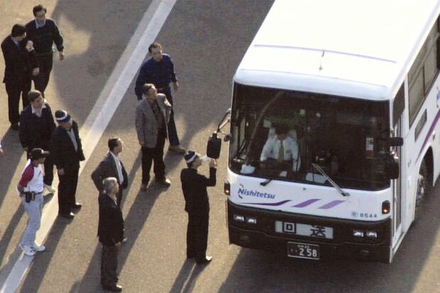 西鉄バスジャック事件　運転席側から西鉄高速バスを乗っ取った犯人を説得する捜査員＝2000（平成12）年5月3日午後5時55分、広島県東広島市の山陽自動車道奥屋パーキングエリアで共同通信社ヘリから　「ザ・クロニクル　戦後日本の70年」第12巻使用画像（P45）