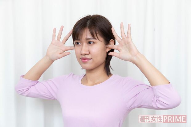 2.人さし指の腹を前向きにし、耳の穴の前にひっかけ、前方向にゆっくり押し出す　撮影／矢島泰輔