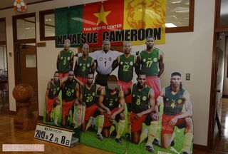 スポーツセンター内に今も設置されている、当時のカメルーン代表選手の写真ボード。来訪者が一緒に撮影できるように、真ん中のビル・チャト選手の顔が抜かれている。本人もこのボードを見て“自分の顔がない!”と驚いたそう。でも笑顔で自ら顔を出して写真撮影したとか