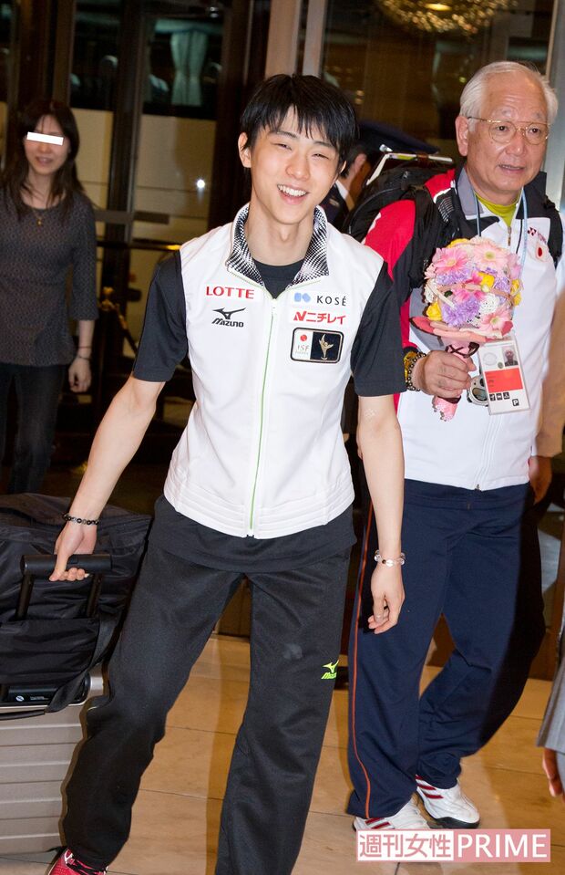 大会では、羽生のそばに常に付き添うトレーナーの菊地氏。左奥はゆづママ（'14年）