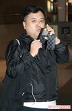 携帯で記者とカメラマンを撮り始める久保田