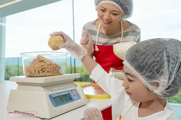 蒸した大豆をミンチ用の機械でつぶし、分量を量る。こうじと塩を混ぜ合わせれば、完成間近!　