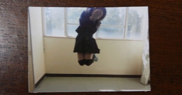 校内で顔を隠してかわいくジャンプ