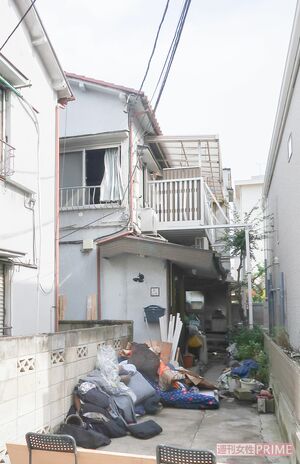 放火されたアパート（奥）。窓は開け放たれ、家財道具は外に出された