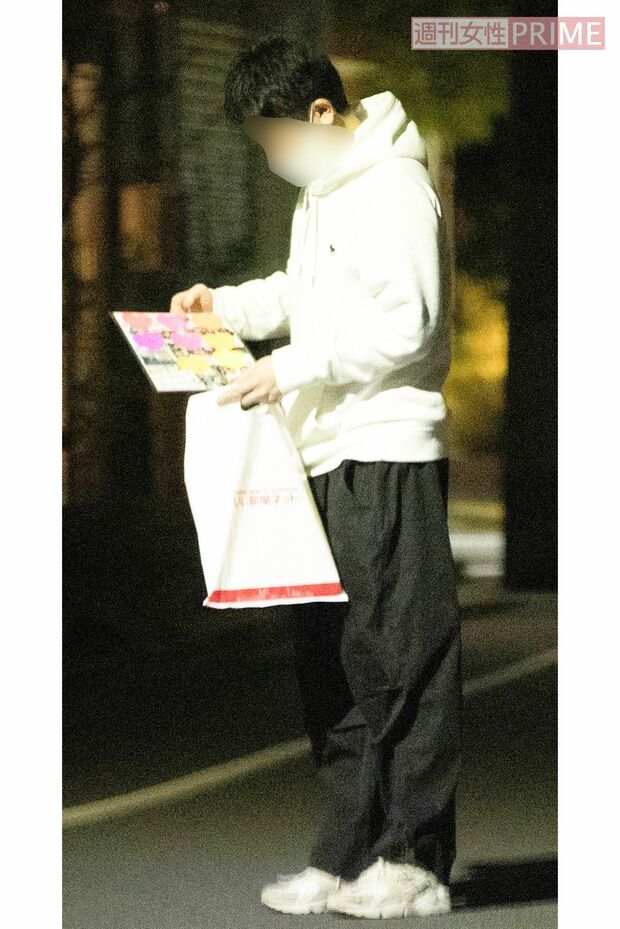 飲み会の会場前で色紙を眺める研修医と思われる男性