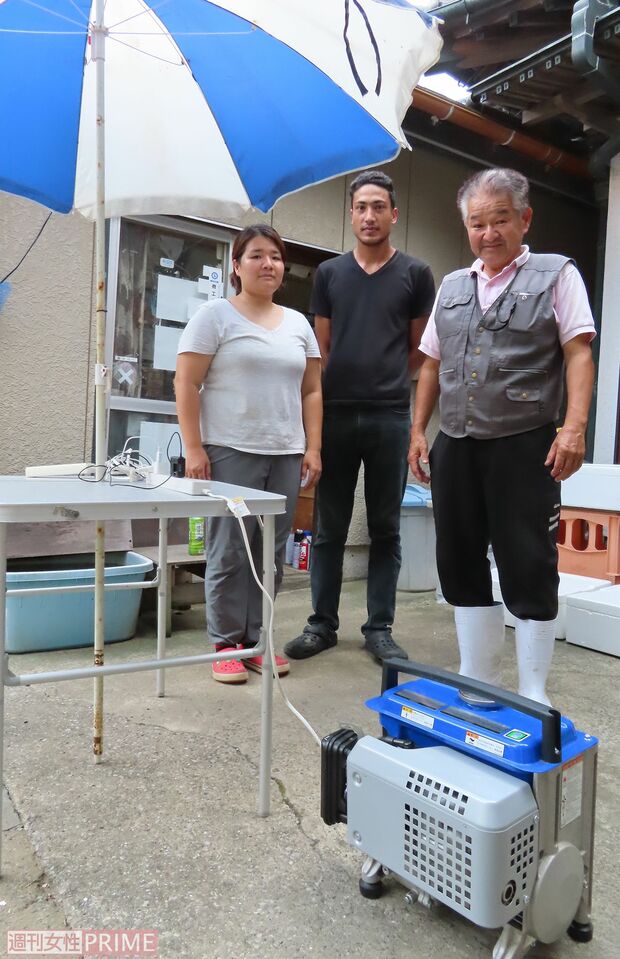 自家用発電機で13口分の同時フル充電基地をつくった蛭田豊さん（右端）と娘さん夫婦＝鋸南町