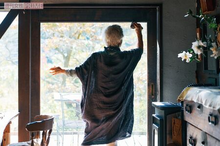 窓を掃除する信田さん。すぐ掃除できるように、掃除道具はキッチン入り口に出しっぱなし。心地よい生活には軽いフットワークも重要だそう(『77歳 365日の紡ぎ方』より)