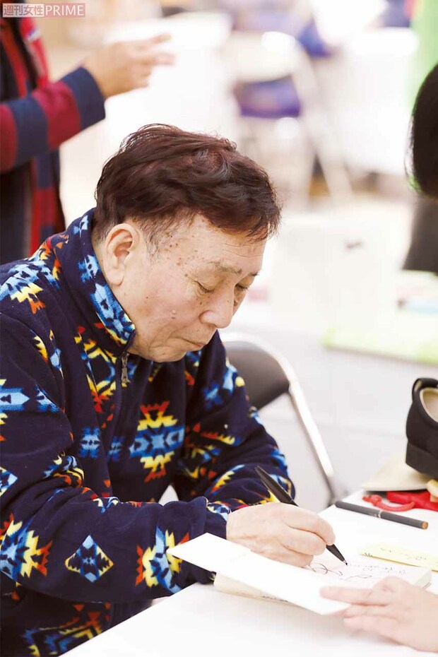 慣れた手つきで、著書にサインをする小雁さん