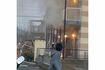 周辺住民が見守る中、白い煙を吐き続ける田原春貴之容疑者の自宅アパートに放水が（目撃者提供）