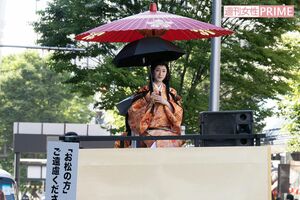 和傘に加え日傘をさして移動車に乗る栗山千明の周りには、撮影自粛を呼びかけるスタッフが