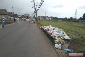 事後現場には献花台があり、たくさんの花が供えられている。奥にあるのは、容疑者がトラックで突撃して折れ曲がった電柱
