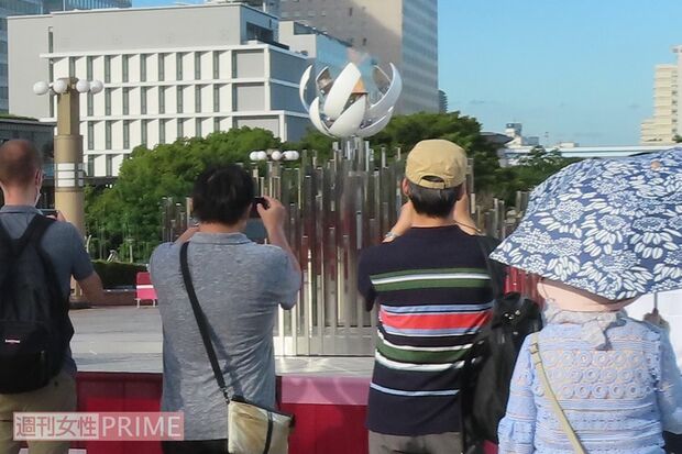 聖火台にカメラを向ける人たち。遠目からしか見ることはできない