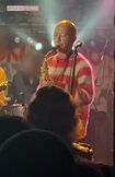 赤と白のボーダーニット姿でサックスを吹くバイきんぐ・小峠英二。ライブ中は観客の笑いを誘うひと幕も