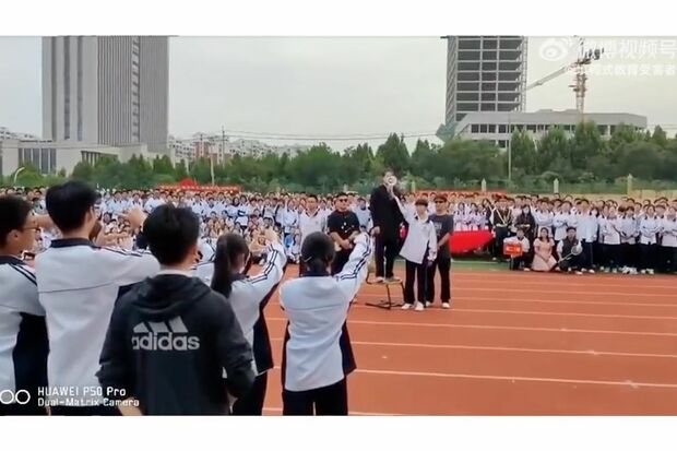 安倍さんのお面をかぶって拡声器に向かって演説する生徒。両隣にはボディーガードに扮した生徒も（Weiboより）