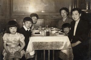 幼少期の家族写真で、右側の母たちに挟まれているのが北原。