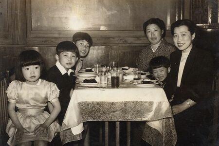 幼少期の家族写真で、右側の母たちに挟まれているのが北原。