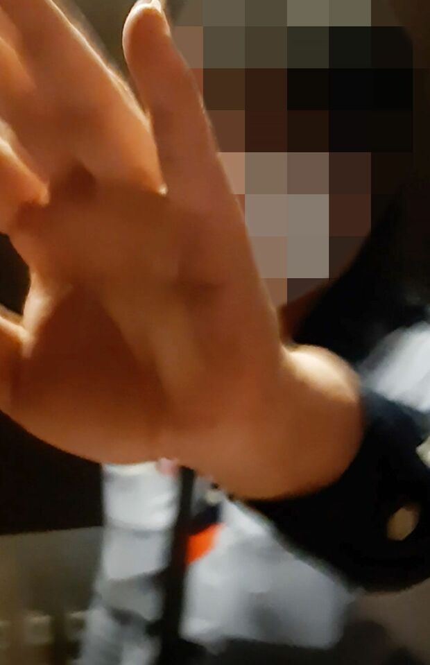 エレベーター内で動画を撮られないように手で遮る郵便局員のA氏