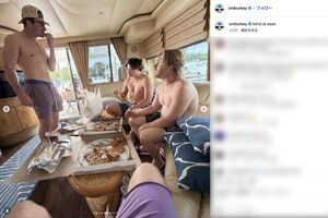 上半身裸の水着姿でピザを食べる村上宗隆(写真中央)。ムキムキな肉体が話題に(ショーン・バーク選手のインスタグラムより)