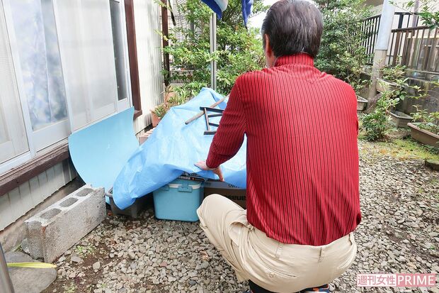 須田容疑者の勤務先から送られてきたブルーシートにくるまれた私物を案内する兄