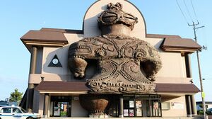 亀ヶ岡遺跡から出土した『遮光器土偶』がモチーフでインパクト大。駅の横には縄文時代風広場も。古代人もサングラスをかけていた!?