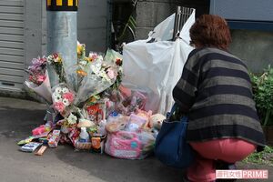 現場マンション前には献花でいっぱいに……