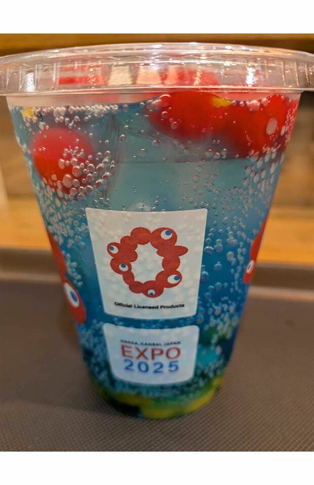 エスタシオンカフェにて販売されている『ミャクミャクフルーツソーダ』。青いソーダに真っ赤なチェリーが浮かぶ(Xより)