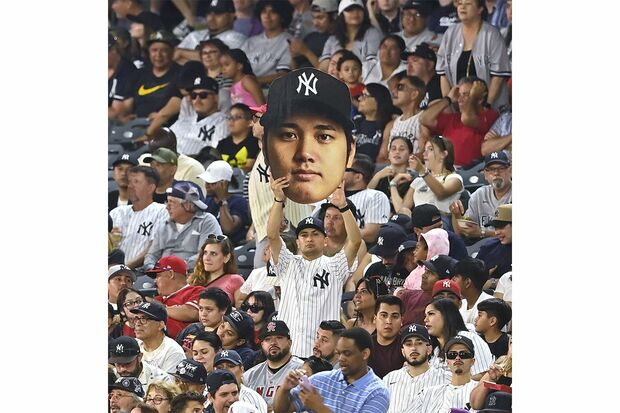 ヤンキースのロゴマークが入った大谷のボードを掲げるファン。ケガで獲得には消極的なようだ