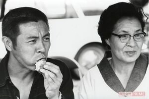 母・キクエさんの隣でおにぎりを頬張る若き日の北島三郎