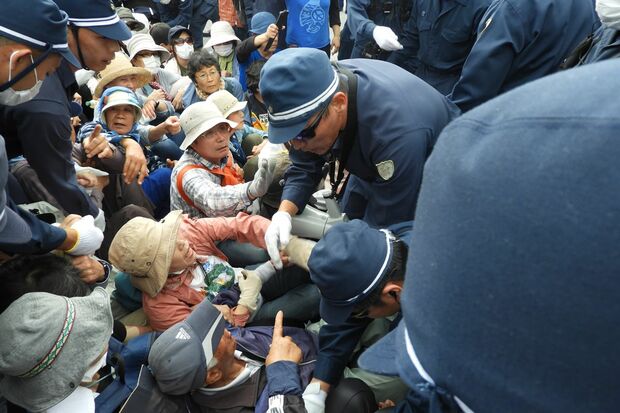 米軍キャンプ・シュワブゲート前に座り込んで抗議する市民と機動隊の間で衝突が起きている