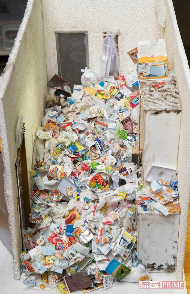 女性（40代）が孤独死したゴミ屋敷をイメージして作られたミニチュア作品。左奥が亡くなっていた場所