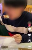 “注文品”として流れている寿司の1貫を、男性が箸で取り、ほおばる(SNSより)