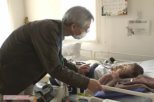 自宅で過ごす伊鈴さんのもとに診察に来た瀬角先生。帰り際には伊鈴さんの手をやさしく握り、伊鈴さんも笑顔で応える 写真/『家族のレシピ』(幻冬舎)より