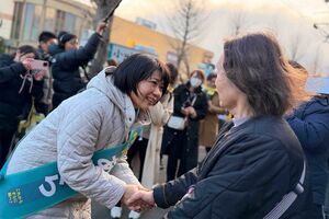 選挙戦で謙虚に市民の手を握る小川晶氏（小川晶氏のSNSより）