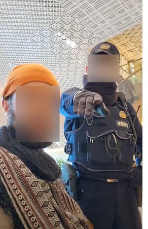 拡散している、ホテルに居座る外国人男性に警察官が退去を求める動画の一部。警察官が撮影を止めるように言っている