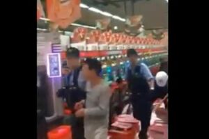 パチンコ台を持参したハンマーで殴打する当時52歳の無職の男性、警察官に連行されているところ（拡散されたSNSより）