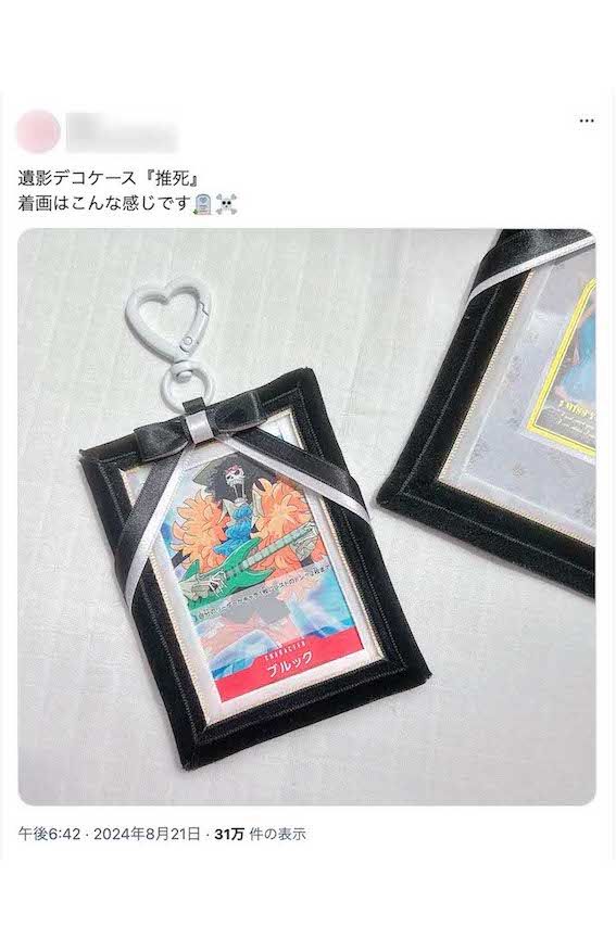《遺影デコケース『推死』 着画はこんな感じです》と、人気漫画キャラクターのカードをセットしたイメージ画像も公開されている(Xより)
