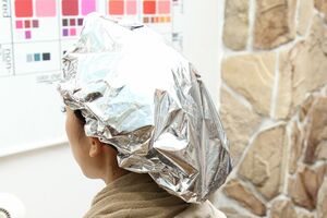 液剤を髪と頭皮になじませ、蒸しタオルを巻いた上からアルミキャップをかぶせる。水素は、pH値を左右しないため、重宝される