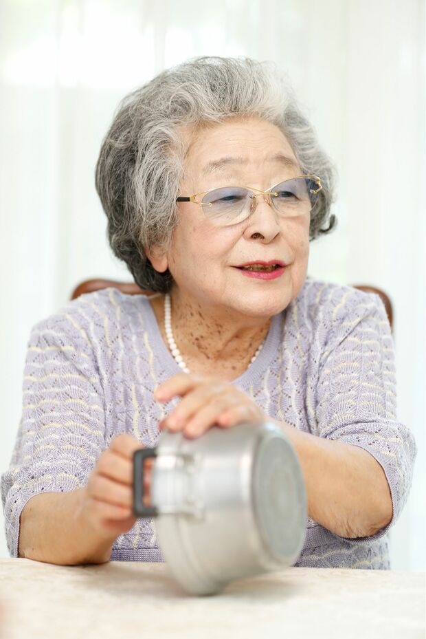愛用の文化鍋を見せながらごはんの炊きどきを教えてくれた鈴木さん　撮影／竹内摩耶