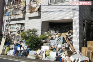 ガレージのゴミは敷地外の歩道にもいまだにはみ出し、通行の妨げになっている