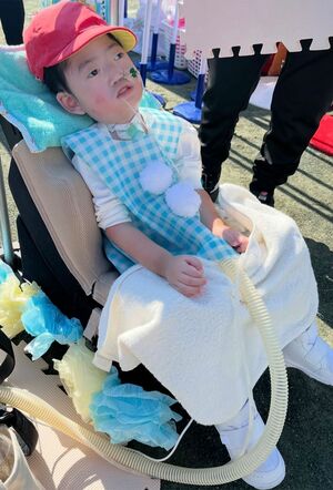 保育園に入園して約1年、人生初めての運動会に参加した新井正輝さん・ゆりこさん夫妻の長男、富士くん。かけっこではカートに乗った富士くんをクラスメイトがひもで引っ張って一緒にゴールした