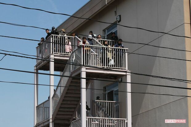 津波警報でサイレンが鳴り響く中、中野栄小学校の屋上に避難する人たち。非常用階段にまで人があふれていた（2011年3月14日）