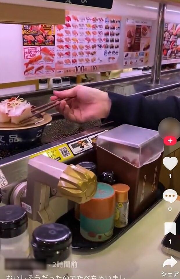 “注文品”として流れている寿司の1貫を、男性が箸で取り、ほおばる（SNSより）