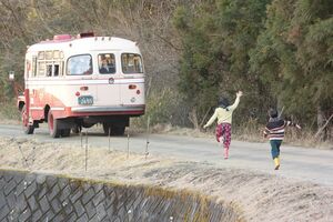 「行ってまいります!」ちぎれるほど手を振る家族や、バスのあとを追いかけてくる妹弟の姿を焼きつけ、みね子たち3人は故郷を旅立った (c)NHK
