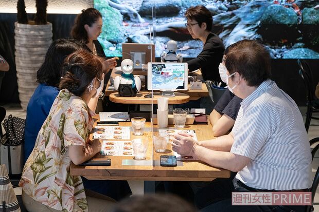 お客さんと会話しながら注文をとるオリヒメ。横に設置されたiPad画面でパイロットの顔写真やプロフィールが紹介され、メニュー表を見ることもできる　撮影／齋藤周造