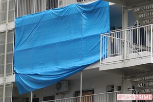 捜査中の現場のマンション。ブルーシートに覆われ