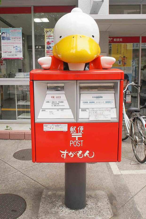 おばあちゃんの原宿と言われる、東京・巣鴨地蔵通り商店街にある巣鴨郵便局前には、どこか懐かしい公式イメージキャラクター“すがもん”デザインを設置。撮影／大嶺こず恵