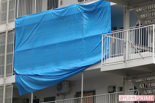 捜査中の現場のマンション。ブルーシートに覆われ