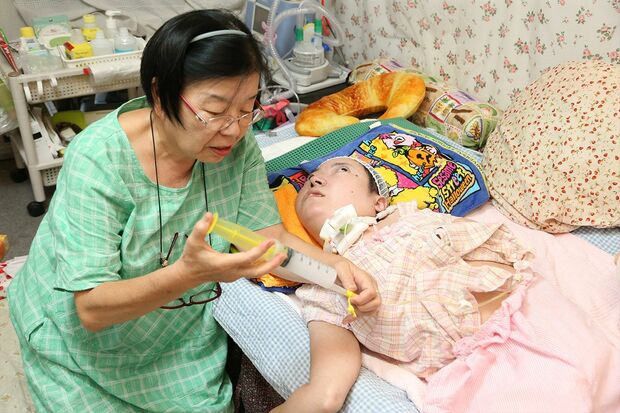 かのこさんは胃ろうで栄養剤や水分をとっている。以前、鼻から胃までチューブを入れていたときに比べると、格段に楽になった　撮影／齋藤周造
