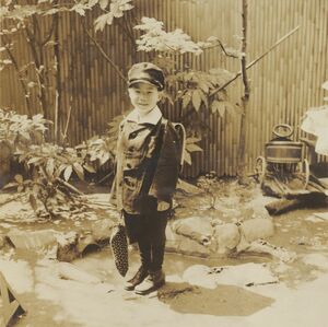 裕福なカメラ商の長男として生まれた。小学校1年生、両国の実家の庭にて