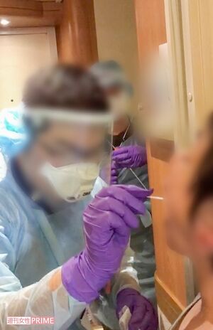 クルーズ船内の検査で口の粘膜を採取される（右）